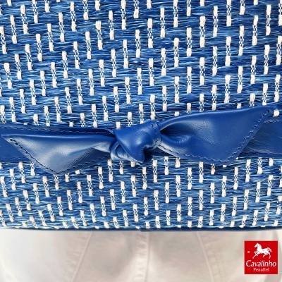 Mala azul e branca com padrão trançado e laço em pele azul