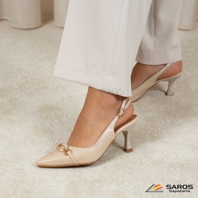 Sapato feminino de salto médio em verniz bege com tira e detalhe dourado.