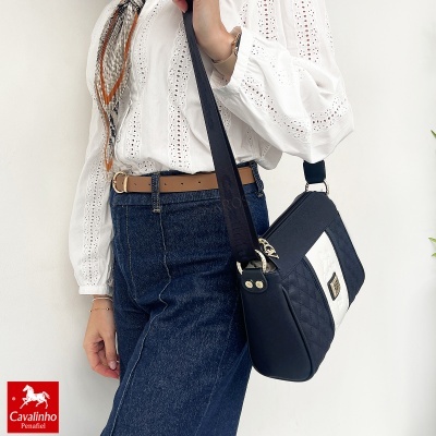 Bolsa preta e branca com padrão em losangos e alça larga preta