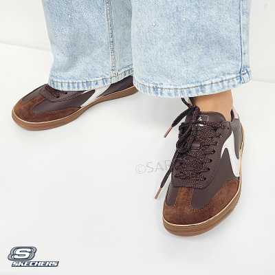 Ténis Skechers castanho escuro com atacadores castanhos usados com calças de ganga claras