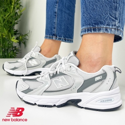 Ténis New Balance 608 cinza e branco usados com jeans