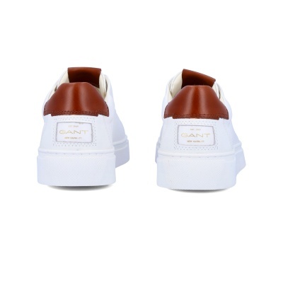 Par de ténis brancos com detalhes castanhos e etiqueta com texto GANT
