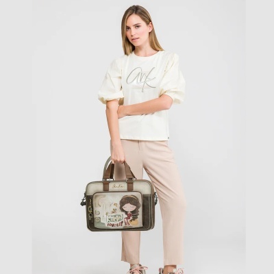 Mulher com t-shirt branca e mala castanha com decoração de personagem desenhada