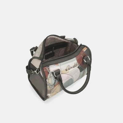 Mala de mão patchwork com cores neutras, alça escura, fecho de correr aberto e pendente metálico.