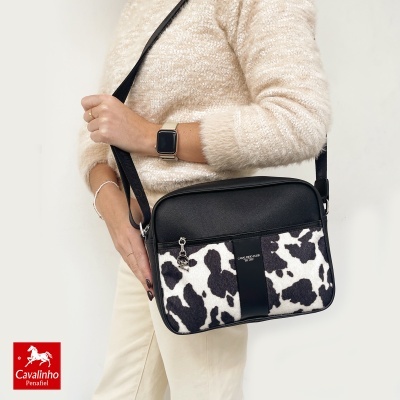 Mala preta e branca com padrão animal Cavalinho Club usada por pessoa com camisola creme