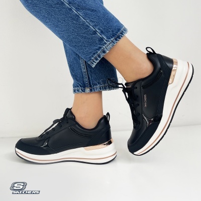 Ténis Skechers pretos com detalhes dourados metálicos e sola branca em fundo branco