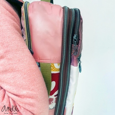 Mochila colorida com compartimentos e zíperes metálicos