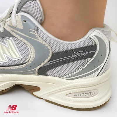 Tênis New Balance cinza e branco com sola bege e castanha