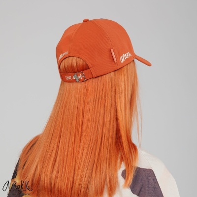 Boné de tecido laranja com texto 'amaka' e fita de ajuste traseira