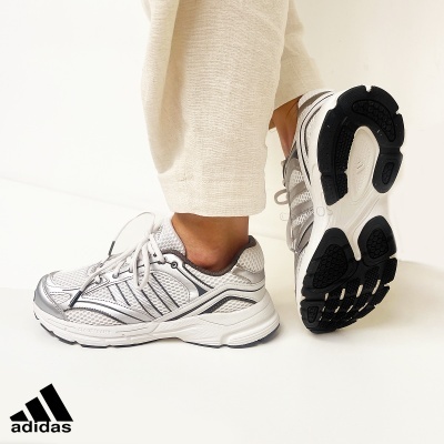 Ténis Adidas de corrida branco e cinza com sola preta em fundo branco