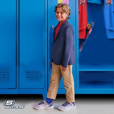 Menino com roupa casual elegante e sapatilhas Skechers junto a cacifos azuis