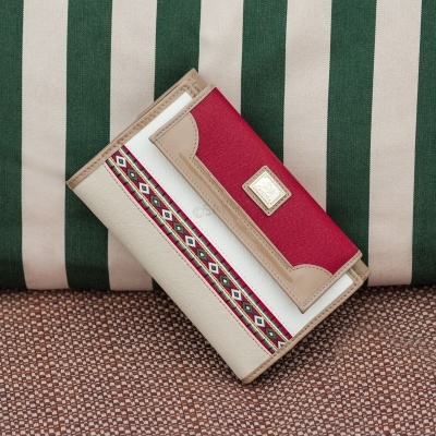 Carteira bege, branca e vermelha com padrão geométrico e aplique metálico em almofadas às riscas verdes e bege