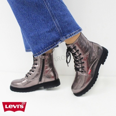 Botas metálicas prateadas Levi's com atacadores pretos e fecho lateral, usadas com calças de ganga.