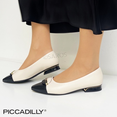 Sapatos pretos e crème com salto baixo e detalhe dourado, usados com saia preta