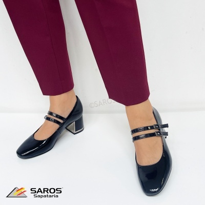 Sapatos pretos em verniz com salto metálico e duas fivelas usados com calças vinho