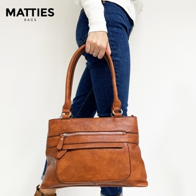 Mala castanha em pele sintética a ser segurada por uma mão