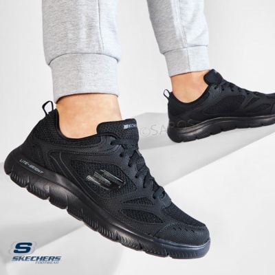 Ténis desportivos pretos Skechers com sola preta e calças cinza claras