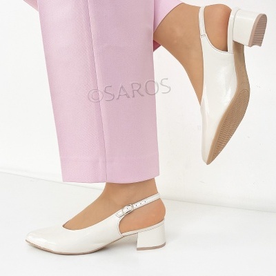 Sapatos brancos de salto médio com tira ajustável, usados com calças rosa claro