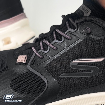 Ténis desportivos pretos e rosa da Skechers em malha com sola branca.