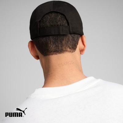 Traseira da cabeça com boné preto e camisa branca, logo PUMA no canto inferior esquerdo.