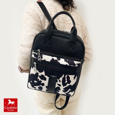 Mochila preta com padrão branco e preto estilo pele de vaca
