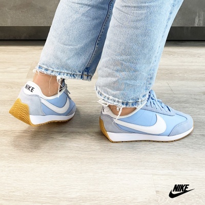 ténis Nike azul claro com sola gum e calças de ganga