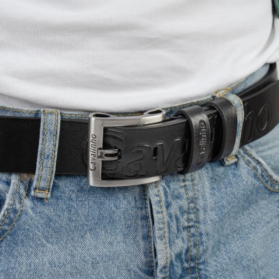 Cinto preto em pele com fivela metálica prateada Cavalinho usado com calças de ganga azuis claras