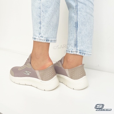 Sapatilhas Skechers cinza com sola branca, usadas com calças de ganga claras.