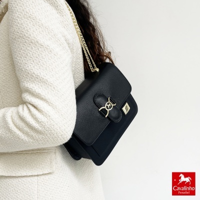 Mala preta em pele com fecho dourado e alça de corrente dourada