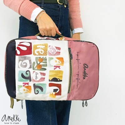 Mochila colorida com painéis brancos e rosa, padrão abstrato e texto decorativo