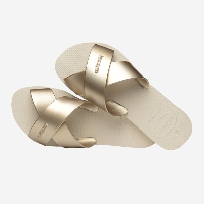 Sandálias Havaianas douradas com tiras cruzadas e sola bege