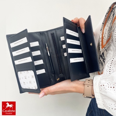 Carteira preta em pele aberta, com vários cartões e fecho dourado, mostrada em mão