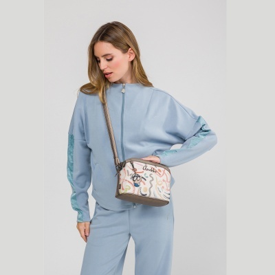 Mulher usando roupa azul clara com mala tiracolo colorida