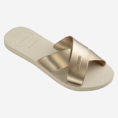 Chinelo rasteiro bege com tiras cruzadas douradas e sola texturada