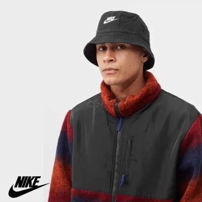 Homem com chapéu preto Nike e casaco colorido com fecho de correr.