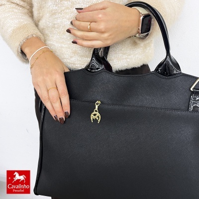 Mala preta tipo tote com alças em verniz e pendente dourado em forma de ferradura com cavalo
