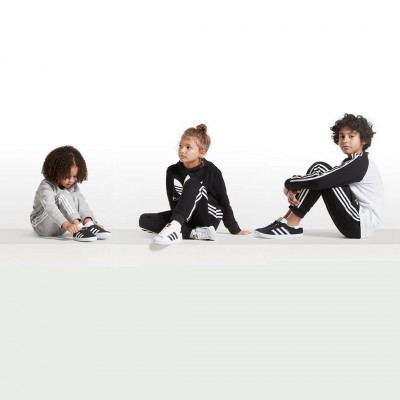 Crianças com roupas desportivas adidas em fundo branco.