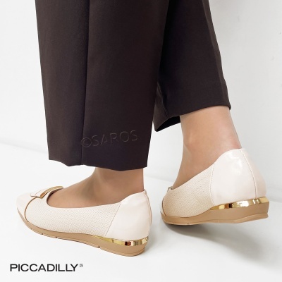 Sapatos femininos bege com detalhes dourados usados com calças pretas