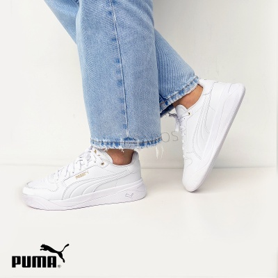 Ténis brancos Puma com calças de ganga azul claro