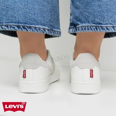 Ténis brancos Levi's com calças de ganga azuis visto por trás