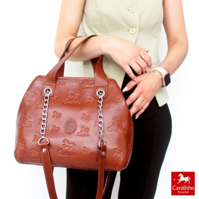 Mala de senhora castanha em pele com textura de cavalos e corrente metálica, com logo Cavalinho Penafiel.