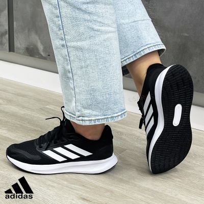 Ténis desportivos Adidas pretos e brancos com riscas laterais brancas