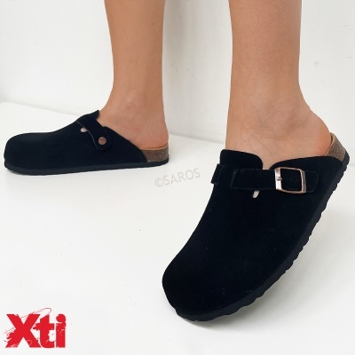 Sapatos mule camurça preta com sola preta e salto cortiça em fundo branco com logótipo Xti