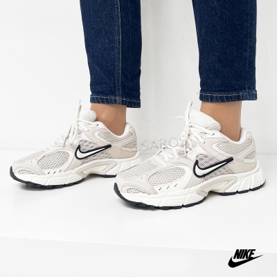 Tênis Nike bege e branco com detalhes pretos usados com jeans