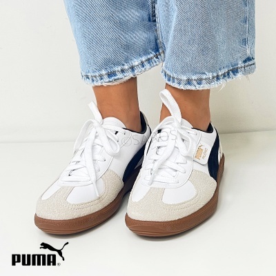 Ténis Puma brancos com detalhes azuis e bege em fundo branco