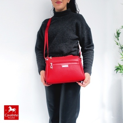 Mala de ombro vermelha com fecho e bolso frontal em fundo branco