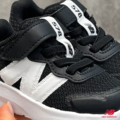 Ténis infantis New Balance pretos com detalhe branco em N e atacadores pretos