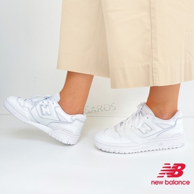 Tênis brancos New Balance usados numa pessoa com calças claras