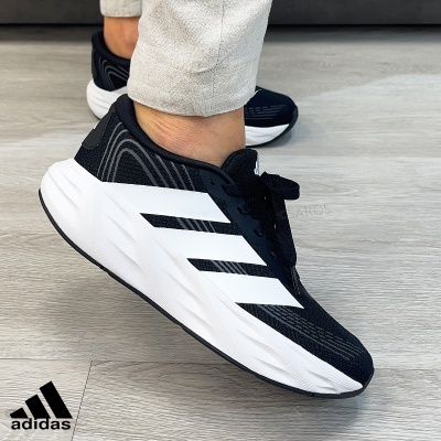 Ténis Adidas pretos com riscas brancas na lateral e sola branca