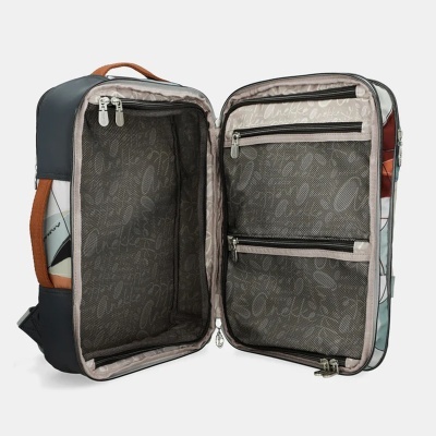 Mala de viagem aberta com interior forrado bege e divisórias em rede preta, exterior com padrão gráfico colorido e alça castanha.